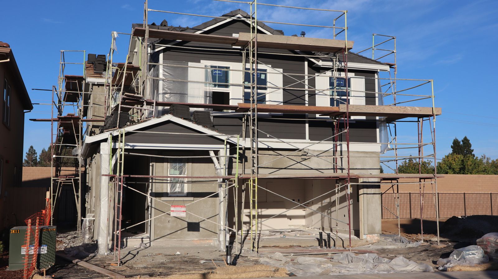 Maison à étage entourée d'un échafaudage pendant des travaux de façade